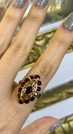 Metal: 10kt Yellow Gold Stone: Garnet Shape: Round And Oval Approximate Garnet Weight: 3.34 ctw Ring Size: 8 Sizing: Please state ring size in personalization box. Weight of entire piece with stones: 4.50 grams Length Of Center Part Of Ring: 23.00mm Width Of Shoulders: 4.00mm Height Of Ring: 27.00mm Formal Marquise Ruby Ring With Accent Stones, Marquise Ruby Jewelry With 17 Jewels, Luxury Marquise Ruby Ring Gift, Elegant Marquise Ruby Ring With Diamond Cut, Luxury Marquise Cut Yellow Gold Ruby Ring, Luxury Marquise Cut Ruby Ring In Yellow Gold, Luxury Yellow Gold Ruby Ring With Marquise Cut, Luxury Yellow Gold Marquise Cut Ruby Ring, Luxury Cluster Ruby Ring Gift