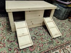 a wooden desk with two open doors on top of it in front of a rug