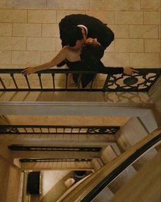 a man and woman kissing on an escalator