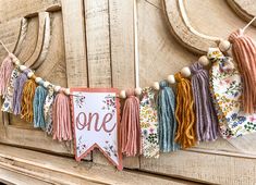 a banner with tassels hanging from it's sides on a wooden door