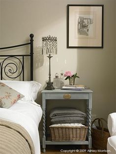 a bedroom with a bed, nightstand and pictures on the wall above it is shown