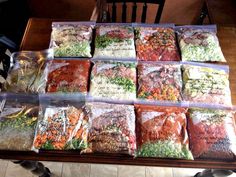 a table topped with lots of bags of food next to a wooden dining room table