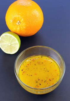 an orange sitting next to a bowl filled with liquid