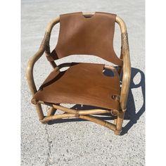 a brown leather chair sitting on top of cement