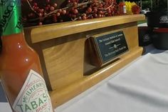 a bottle of hot sauce sitting on top of a wooden box next to other bottles