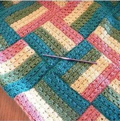 a crocheted blanket with a pair of scissors on it