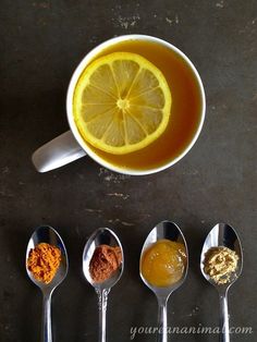 five spoons with different types of food on them and one has an orange slice in the middle