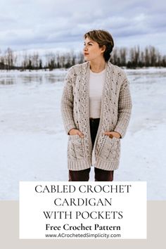 a woman standing in the snow wearing a cabled crochet cardigan with pockets