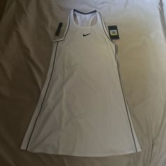 a women's nike tank top laying on a bed with the tag attached to it