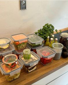 there are many containers on the counter with food in them