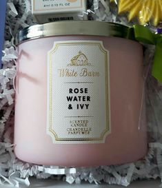 a pink candle in a gift box with flowers