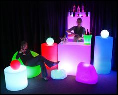 a woman sitting in a chair surrounded by glowing furniture