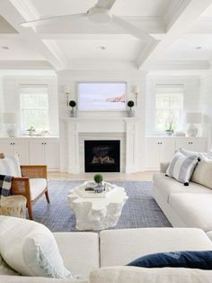 a living room filled with furniture and a flat screen tv mounted on the wall above a fire place