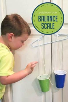 a little boy that is playing with some buckets on the door handle to balance scale