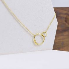 "Wonderfully modern, our interlocking circle necklace features a small circle clasping onto a larger circle that is made up of two separate arcs for a truly eclectic design. Entirely handmade, the circles are 22K yellow gold fill over sterling silver (5 micrometers of gold). The small circle/large circle motif is a wonderful way to represent a mother with a new baby, making it an ideal gift for a new mom. Small circle is 8mm in diameter, 1.2 mm thick. Large circle is 18mm in diameter with the la Interlocking Circle Necklace, Gold Circle Necklace, Concentric Circles, Small Circle, Eclectic Design, Circle Necklace, Recycled Sterling Silver, Gold Filled Chain, Gold Plated Silver