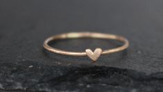 a heart shaped ring sitting on top of a rock