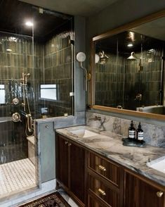 a bathroom with marble counter tops and wooden cabinets, along with a walk in shower