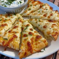 pizza slices on a plate with a small bowl of ranch dressing in the middle and garnished with parsley