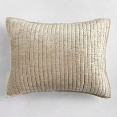 a cream colored pillow on a white wall