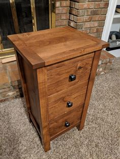 a wooden cabinet sitting in front of a brick fireplace