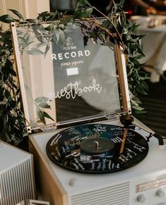 an old record player sitting on top of a table next to a mirror with writing on it