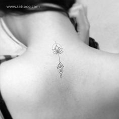 the back of a woman's neck with a flower tattoo on it