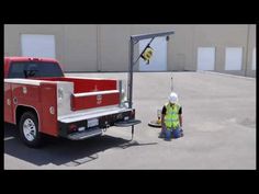 a man standing next to a red truck with a crane on it's back