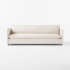 a white couch sitting on top of a white floor