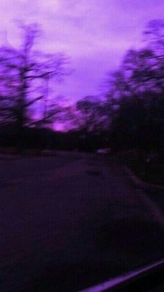 the sky is purple and there are trees in the background