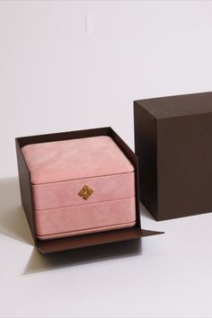 an open pink box sitting on top of a white table next to a brown box