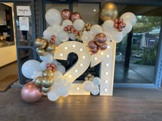 the number twenty two decorated with balloons and streamers in front of an open door