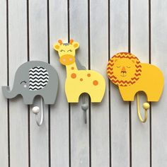 three elephant and giraffe hooks on a wall