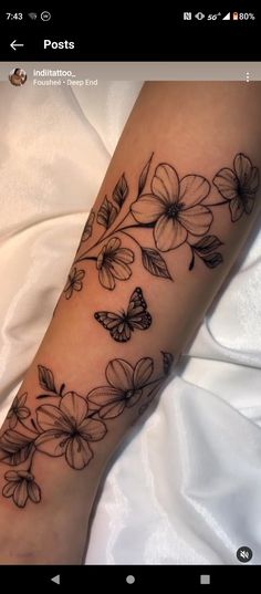 a woman's arm with flowers and butterflies on it