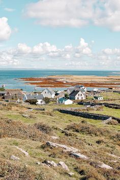 a small town by the ocean with houses on it's sides and water in the background