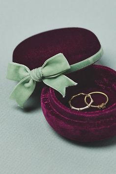 two wedding rings in a velvet box with a bow