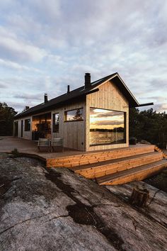 a wooden house sitting on top of a rocky hillside