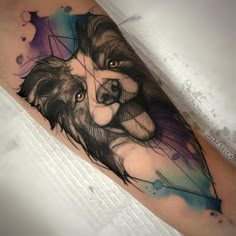 a dog tattoo on the leg with watercolors and black ink, it looks like he is holding his owner's head