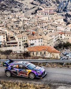 a car driving down a road with lots of buildings in the background