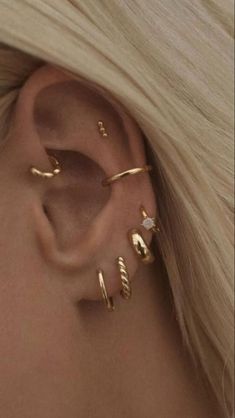 a woman with blonde hair wearing three different ear piercings