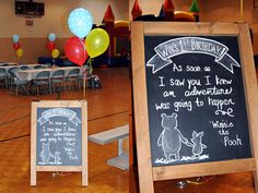 a birthday party with winnie the pooh decorations and chalkboard signs on the floor