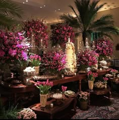 a room filled with lots of different types of flowers and vases on top of tables