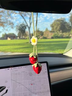 two strawberries hanging from a car dashboard