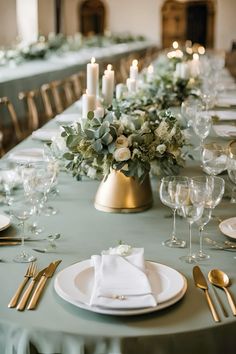 a table set with candles, plates and silverware