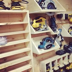 many different tools are displayed on shelves in a room with wood shelving and plywood flooring