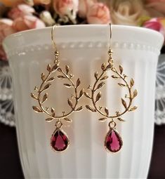 Gorgeous earrings feature gold plated brass laurel wreath charm and teardrop burgundy faceted glass encased in gold frame. On gold plated brass ear wires. These earrings are elegant and lovely for any occasion! MEASUREMENTS: Earring length: 50 mm Drop size: 40 mm Ruby drop size: (including loop): 8 X 14 mm For matching earrings, please click to this link: https://www.etsy.com/hk-en/listing/1128095371/ Purchase over $40 enjoys free shipping! Coupon code 'freeshipping1'. Free Gift Wrapping on requ Gold Laurel Wreath, Loop Earrings, Laurel Wreath, Crystal Drop Earrings, Flower Bracelet, Faceted Glass, Matching Bracelets, Gorgeous Earrings, Bridal Earrings