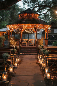 The image shows a beautifully lit outdoor wedding venue with a charming wooden gazebo adorned with string lights. The pathway to the gazebo is lined with lanterns, creating a romantic and cozy ambiance, ideal for a memorable outdoor wedding ceremony. Outdoor Wedding Ideas Decoration, Garden Wedding Themes, Gazebo Lights, Wedding Ideas Decoration, Wedding Ideas Garden, Outdoor Night Wedding, Winter Themed Wedding, Gazebo Wedding Decorations, Sophisticated Garden