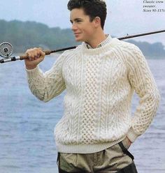 a young man holding a fishing rod by the water