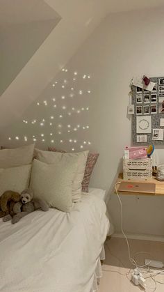 there is a bed with white sheets and lights on the headboard in this room