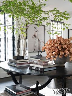 there is a table with books and a vase on it