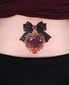 a woman's stomach with a heart shaped brooch attached to the back of her belly